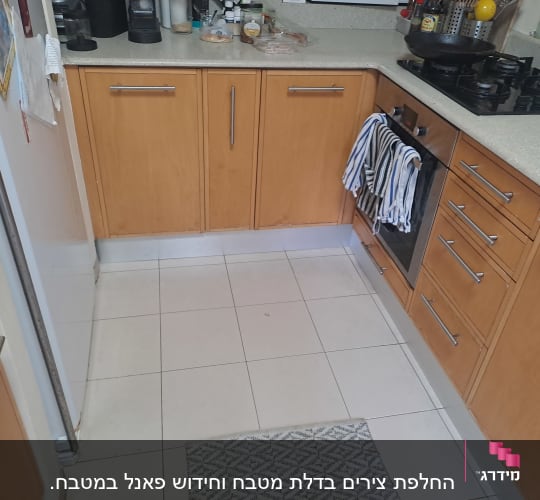 מטבח עם ארונות עץ, כיריים ותנור